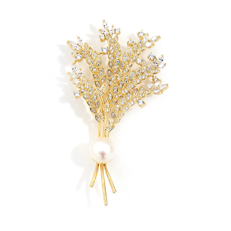 Gold brooch with crystal embellishments on a white background