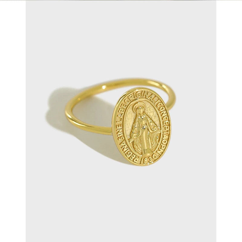 Gold ring with a circular emblem on a white background