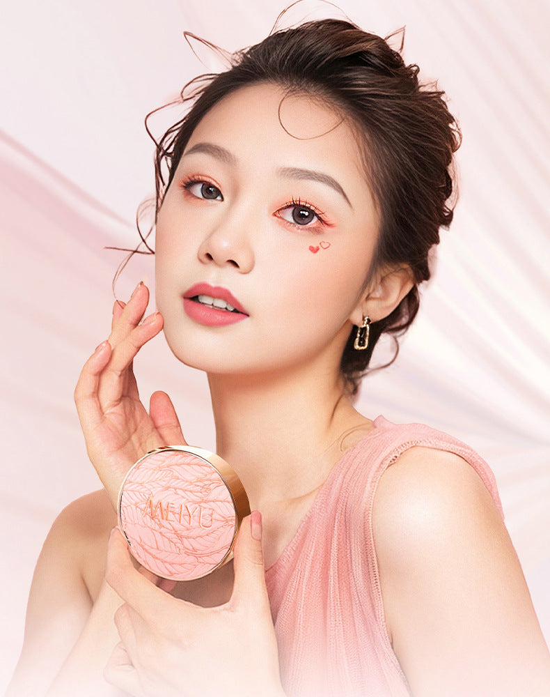 Woman holding a pink compact mirror with a soft pink background