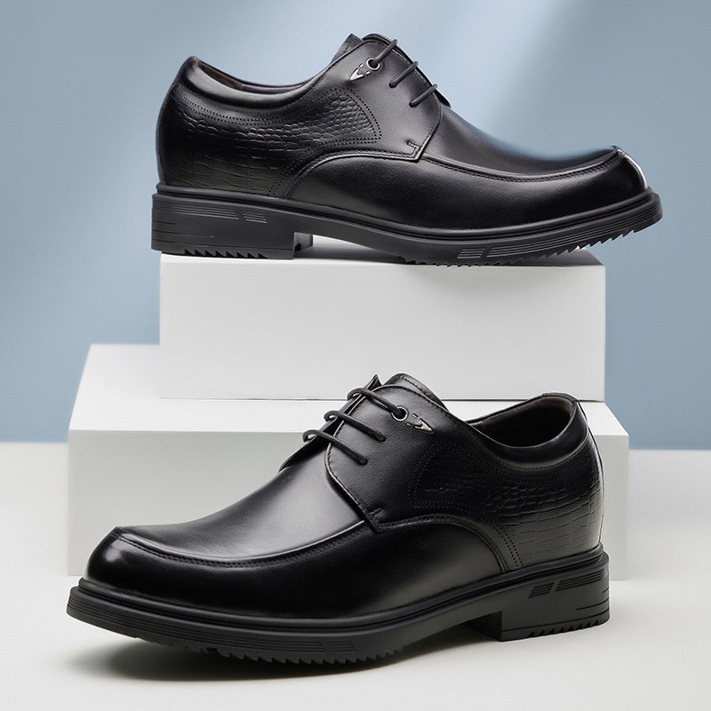 Two black leather dress shoes on white and gray blocks with a light blue gradient background.