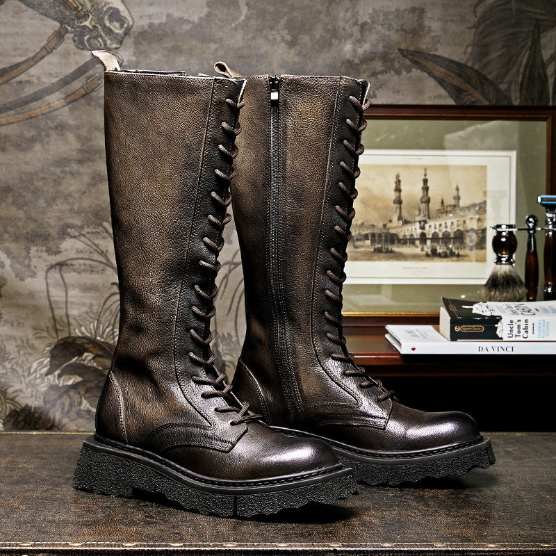 Pair of brown leather boots with a decorative lacing pattern on a textured surface.