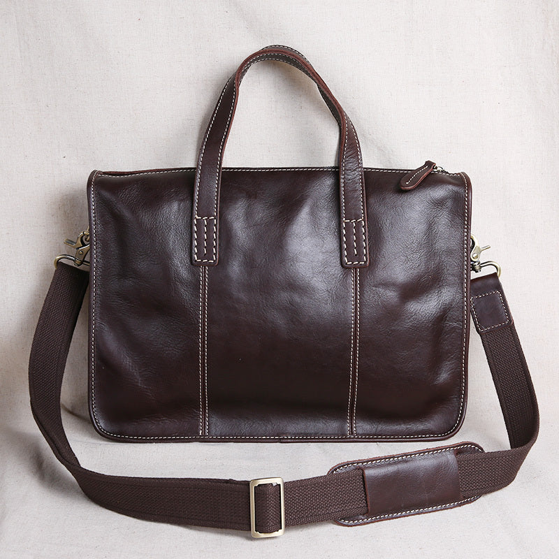 Brown leather bag with a shoulder strap on a light gray background