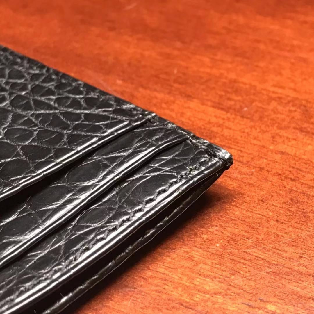 Black leather wallet on a wooden surface
