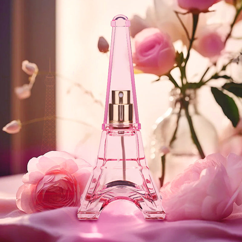 Pink Eiffel Tower-shaped perfume bottle with flowers in the background
