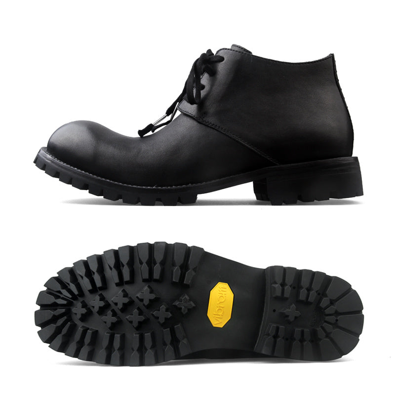Black leather boot with a close-up of the sole on a white background