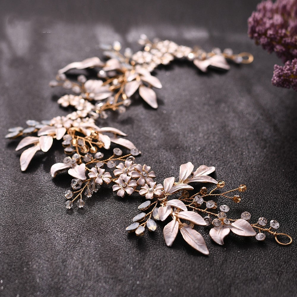 Decorative floral hairpiece with gold and silver accents on a dark surface.