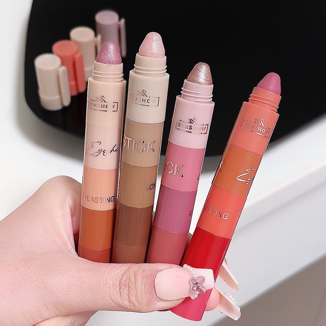 Hand holding four lipsticks with a blurred background