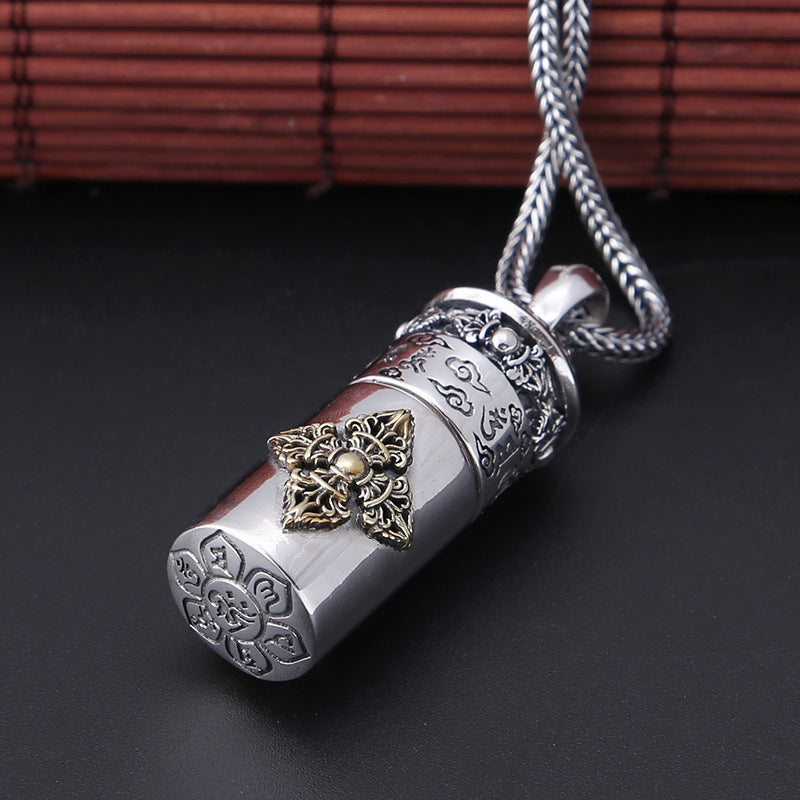Silver and gold decorative pendant on a dark background