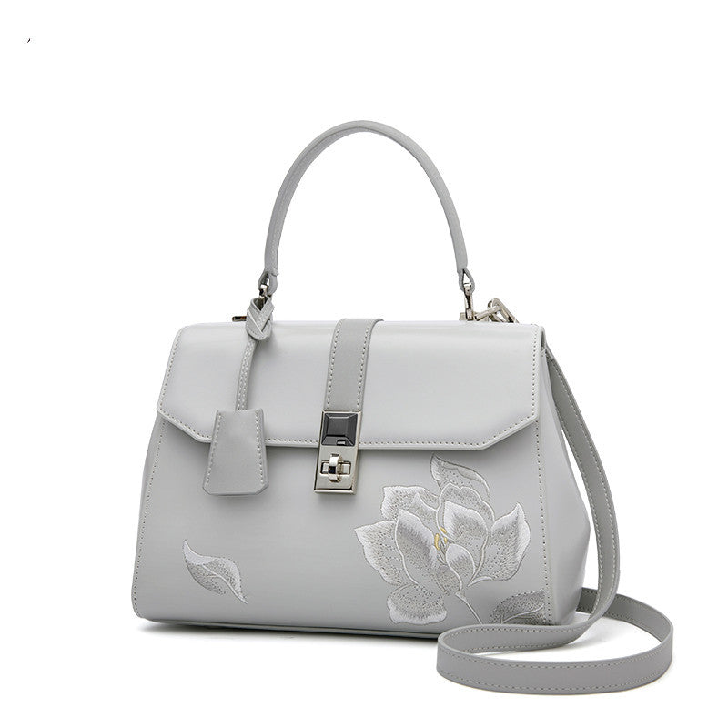 Gray handbag with floral embroidery on a white background