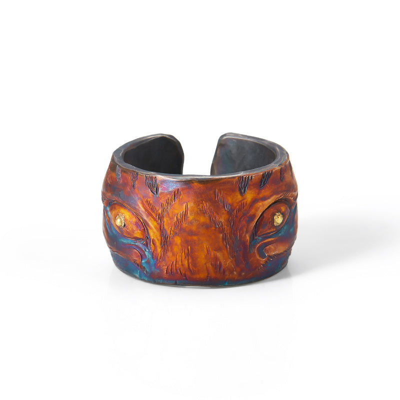 Ceramic bracelet with brown and blue glaze on a white background