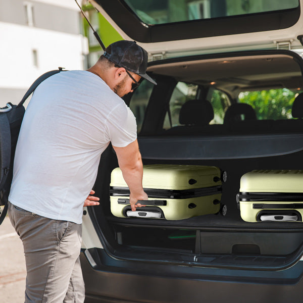 Man loading a suitcase into the trunk of a car