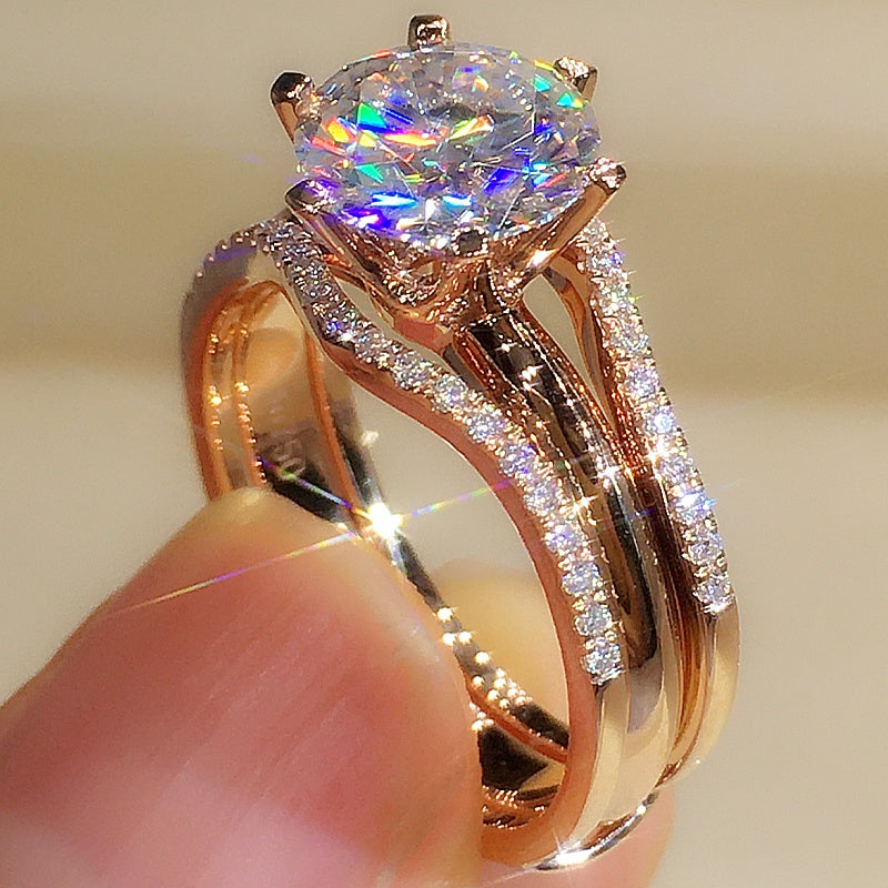 Rose gold ring with a large diamond and smaller diamonds on the band against a neutral background