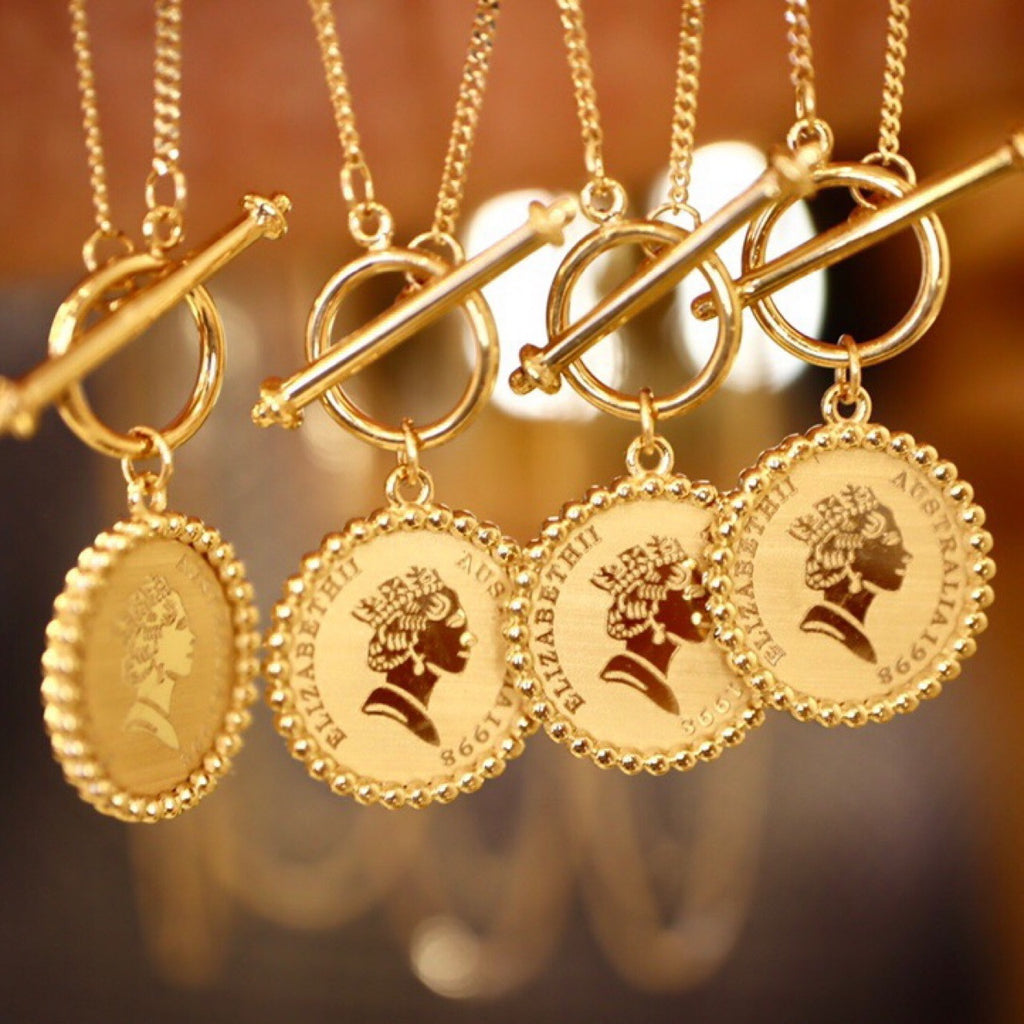 Gold necklaces with coin-shaped pendants featuring profiles on a blurred background