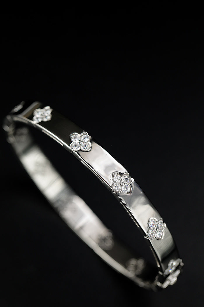 Silver bracelet with floral designs on a black background
