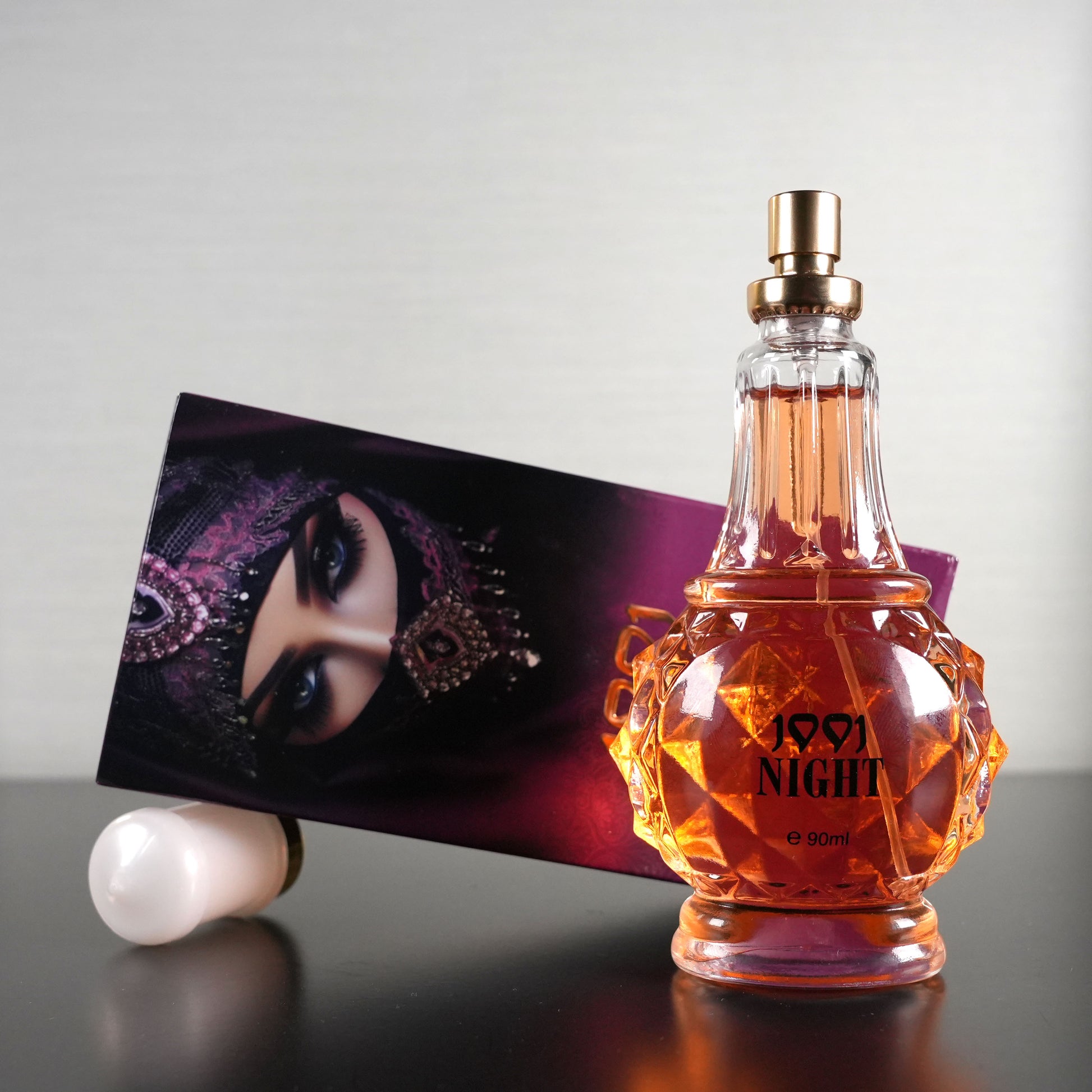 Perfume bottle labeled '1957 Night' with a decorative box on a reflective surface.