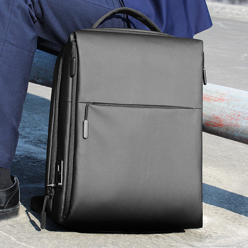 Black backpack on a person sitting by a waterfront