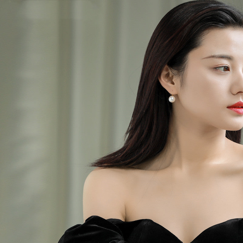 Woman wearing a black off-shoulder top with a blurred background