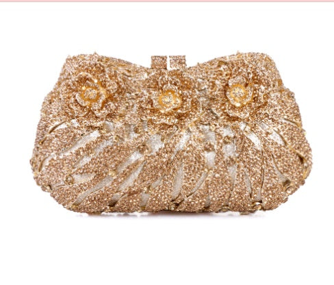 Gold beaded clutch bag with floral designs on a white background