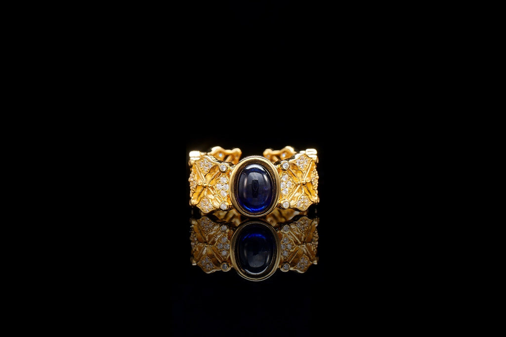 Gold ring with a blue gemstone on a black background