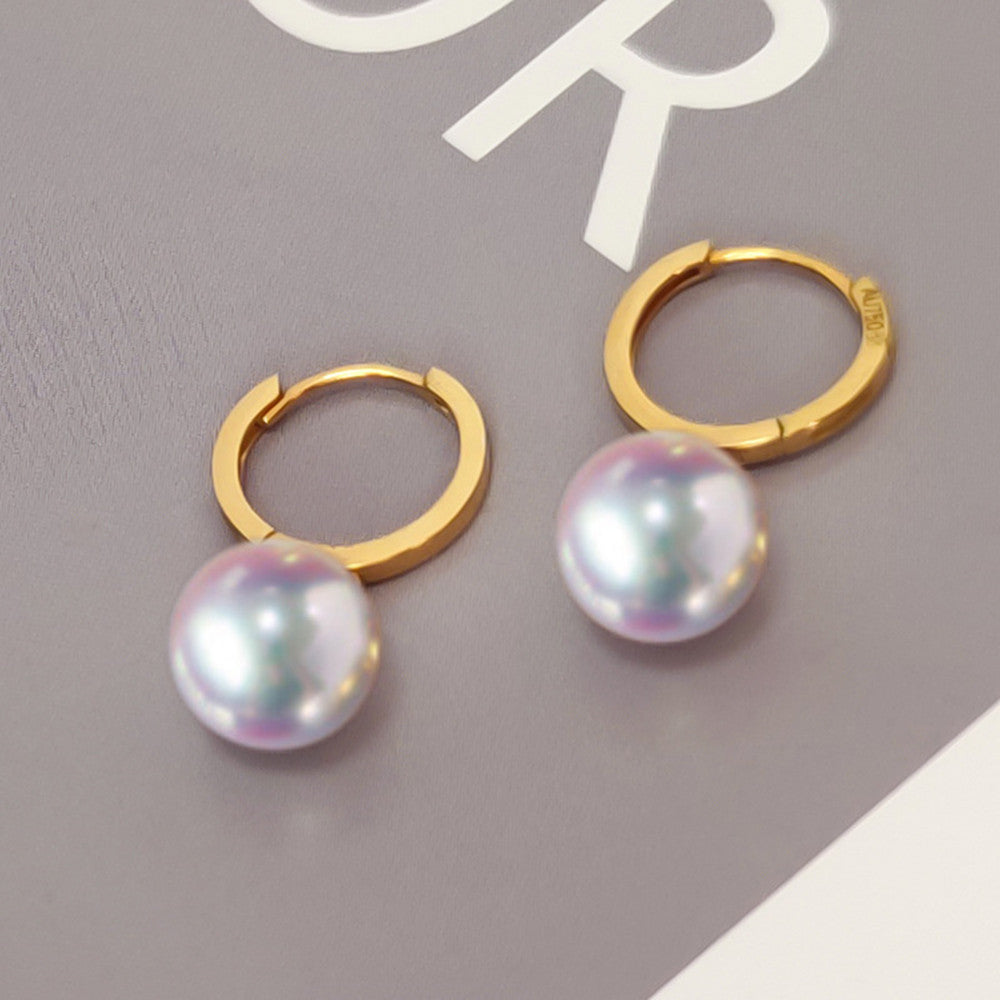 Gold hoop earrings with multicolored pearls on a gray background
