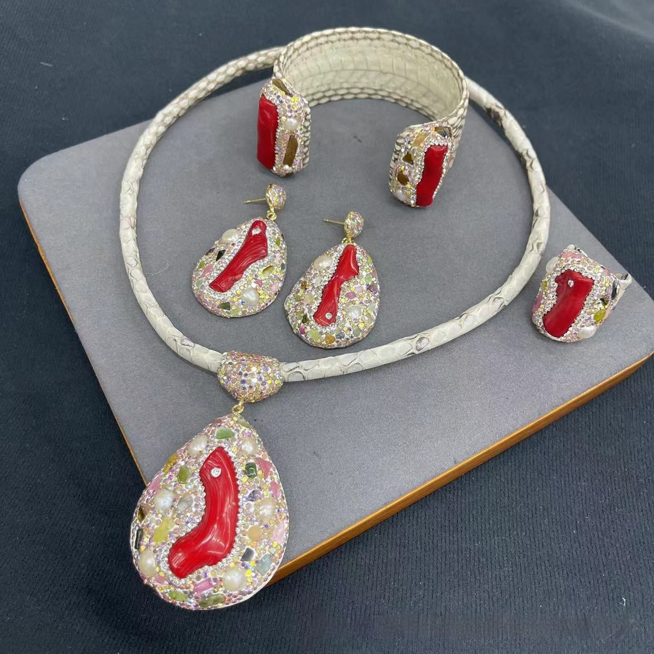 Jewelry set with necklace, earrings, and bracelet on a gray surface