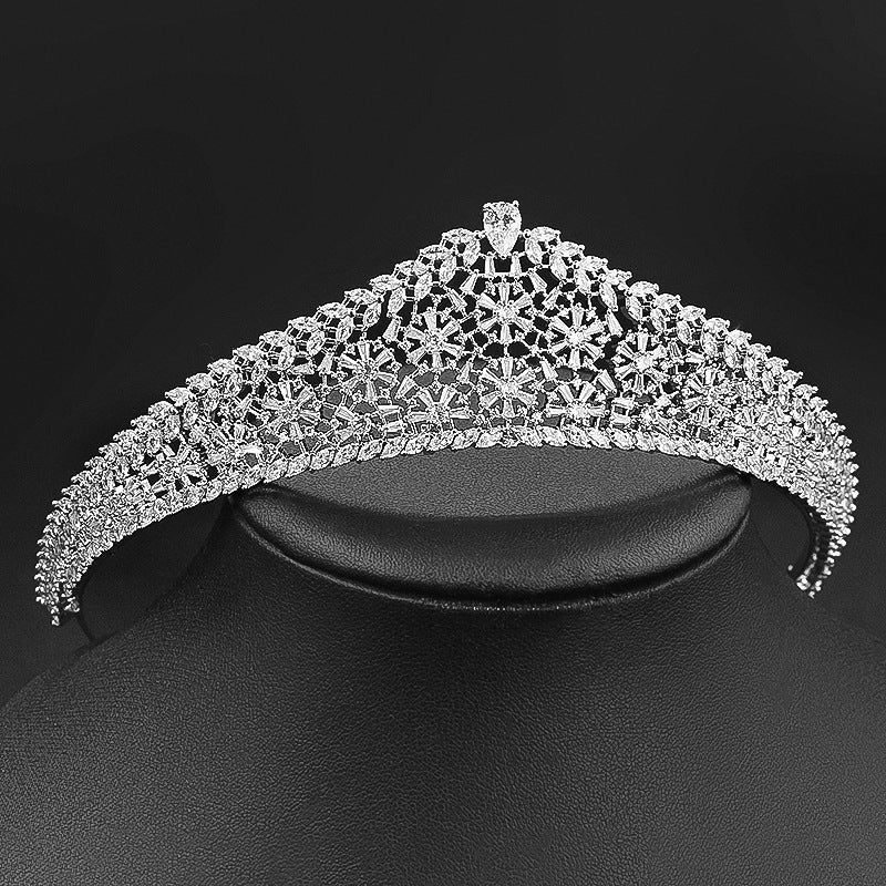 Silver tiara on a black stand against a black background