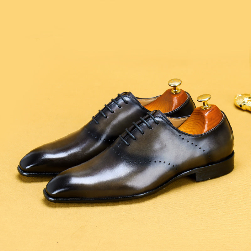Pair of black dress shoes on a yellow background