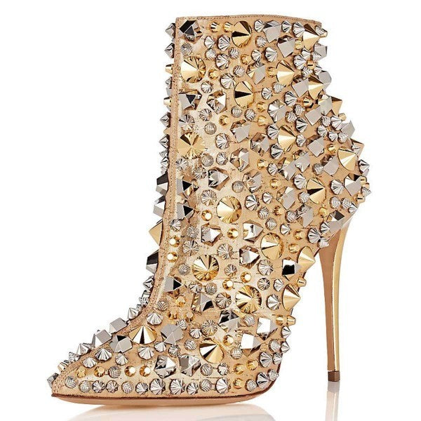 High-heeled shoe with gold and silver studded design on a white background