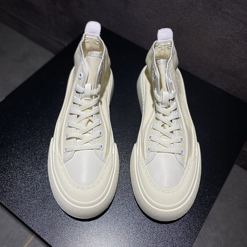 Pair of white high-top sneakers on a dark surface
