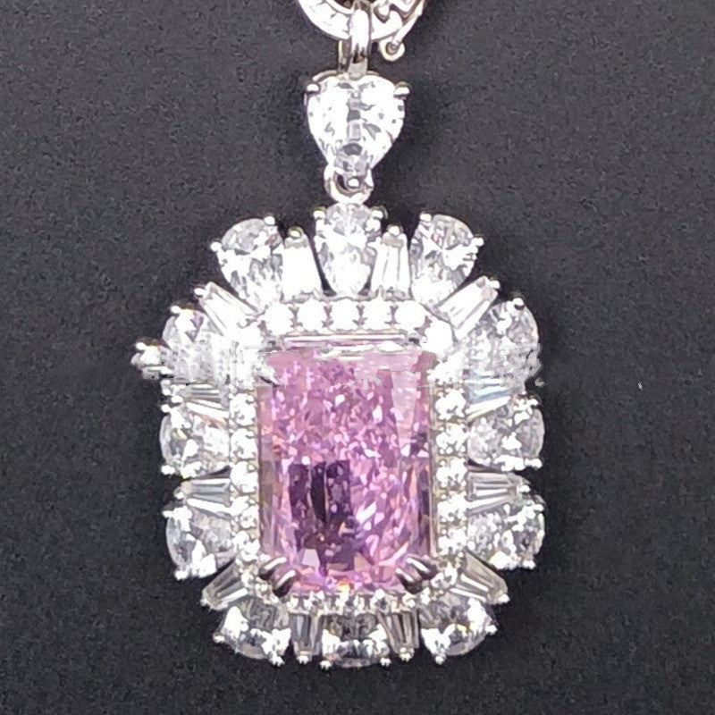 Pink gemstone pendant with diamond accents on a black background