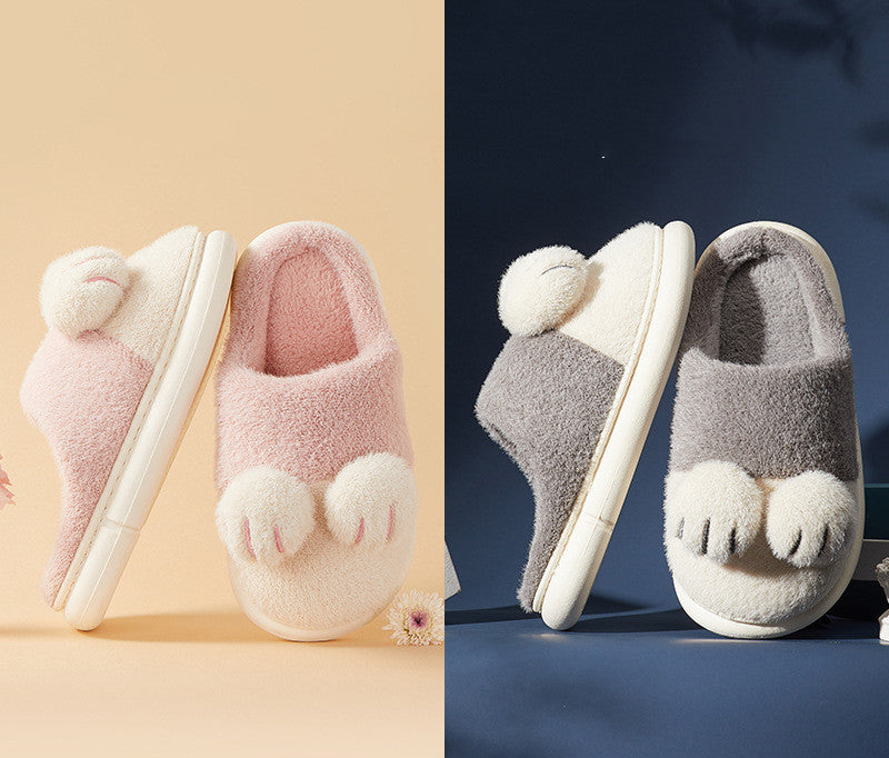Pair of pink slippers with paw-like toes on a beige background, and a pair of gray slippers with paw-like toes on a blue background.