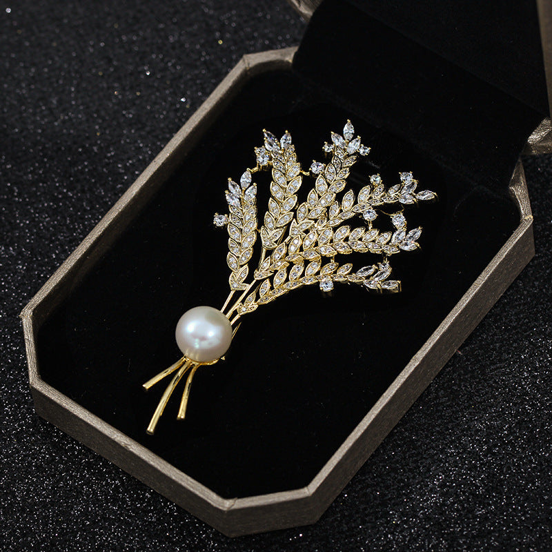 Gold leaf brooch with a pearl on a black display box
