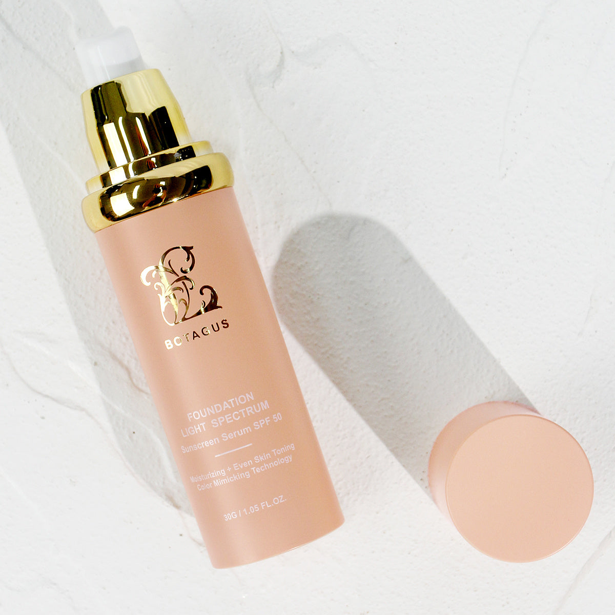 Foundation bottle with gold cap on a white background