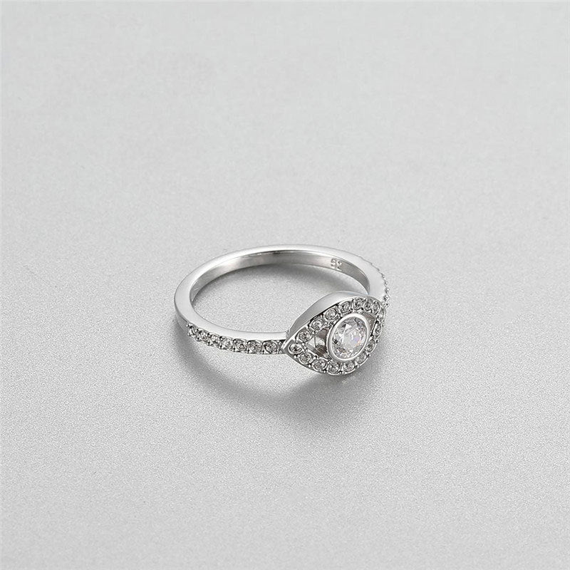 Silver ring with a diamond on a light gray background