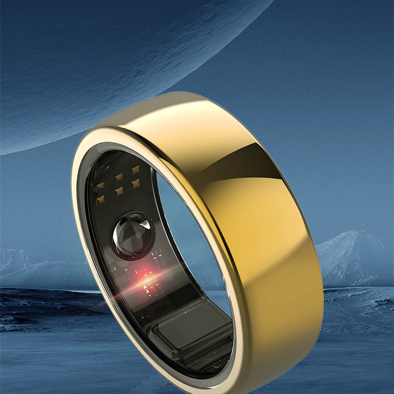 Gold ring with electronic components against a mountainous landscape
