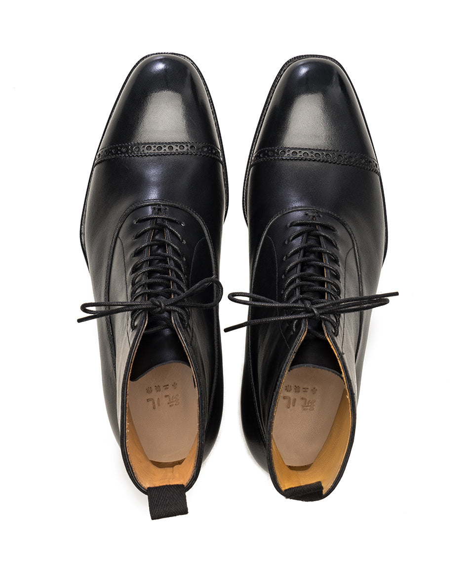 Pair of black leather dress shoes on a white background