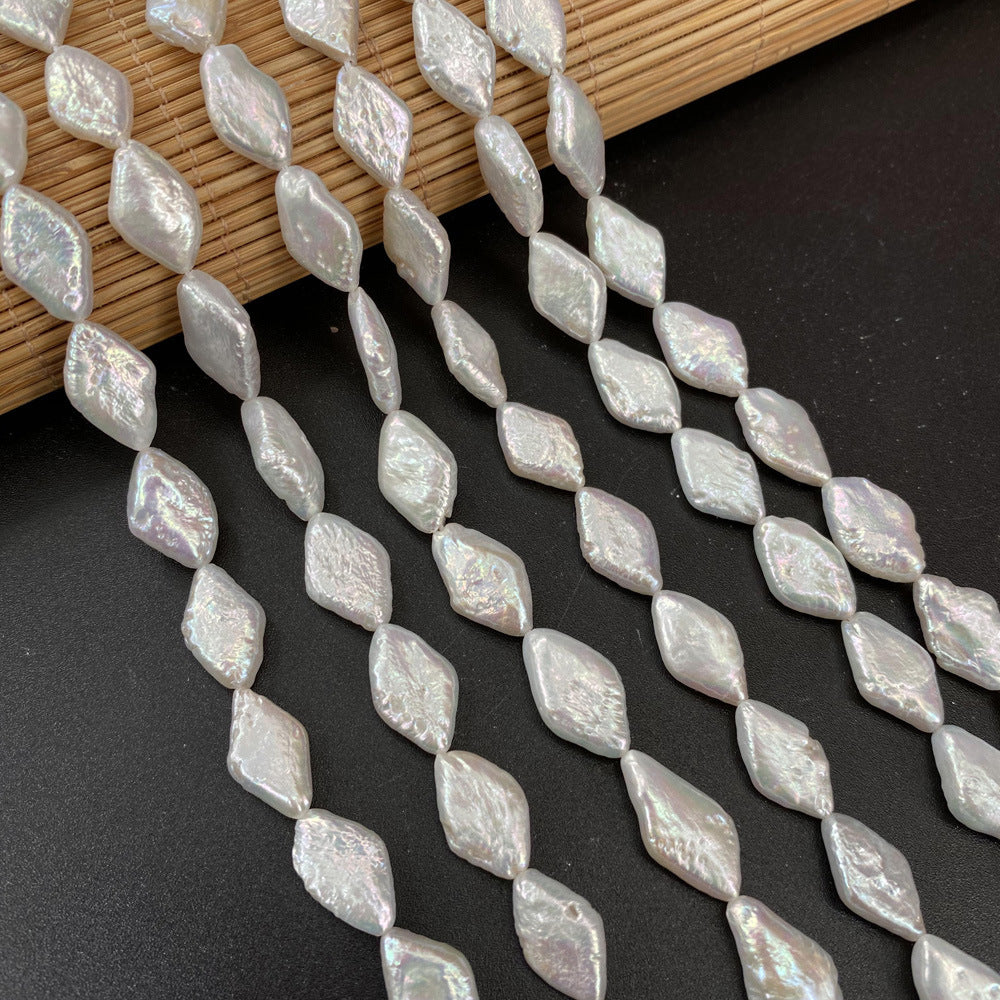 Pearlized diamond-shaped beads on a black surface with a wooden background