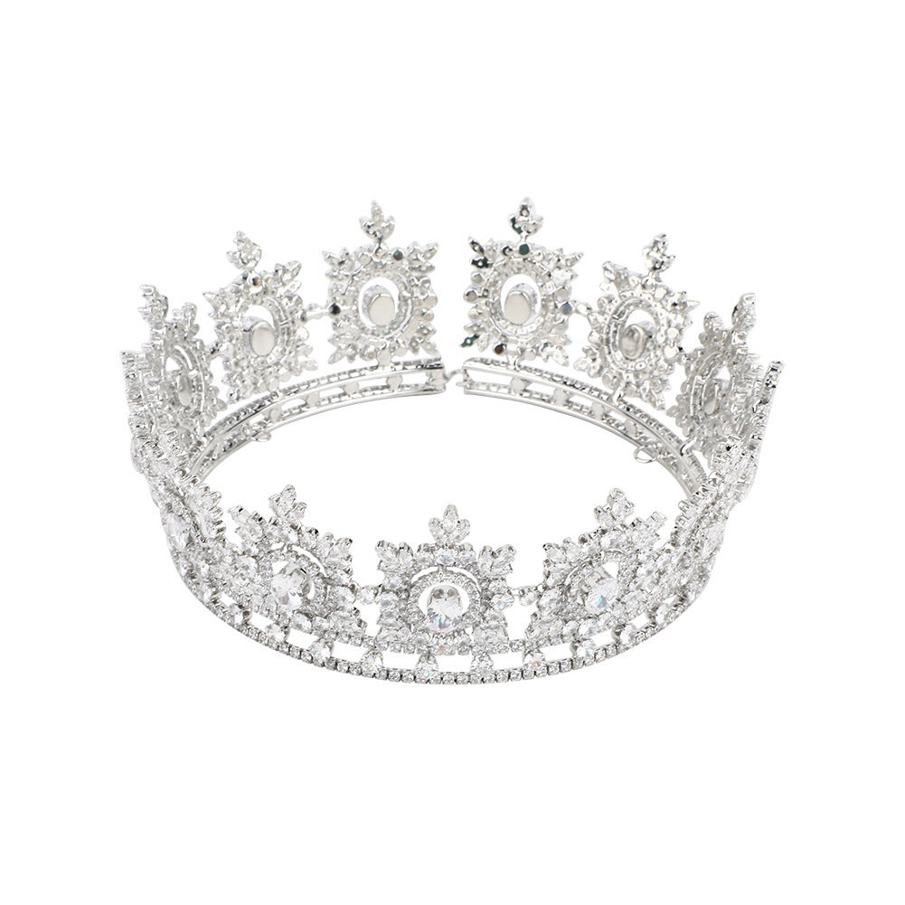 Elegant silver tiara with intricate design on a white background