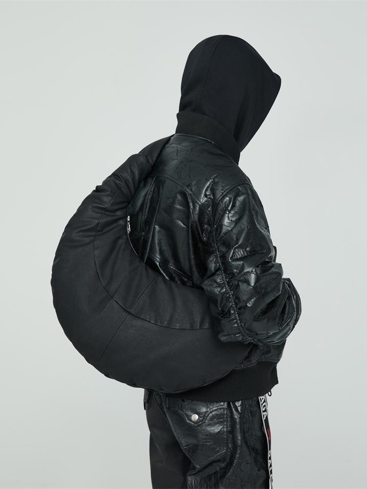 Person wearing a black quilted jacket and pants on a light gray background
