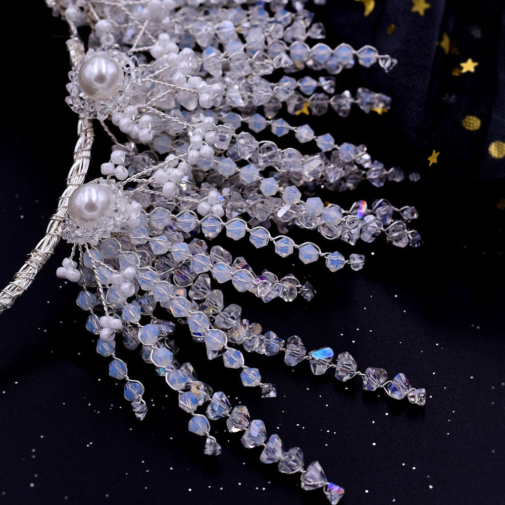 Decorative hairpiece with pearls and crystals on a dark background