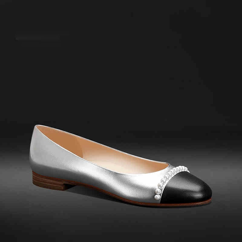Two-toned shoe with pearl detail on a dark background
