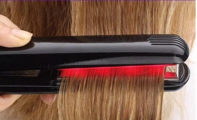 Hair straightener with red light being used on hair