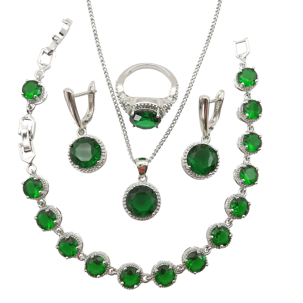 Jewelry set with green gemstones on a white background