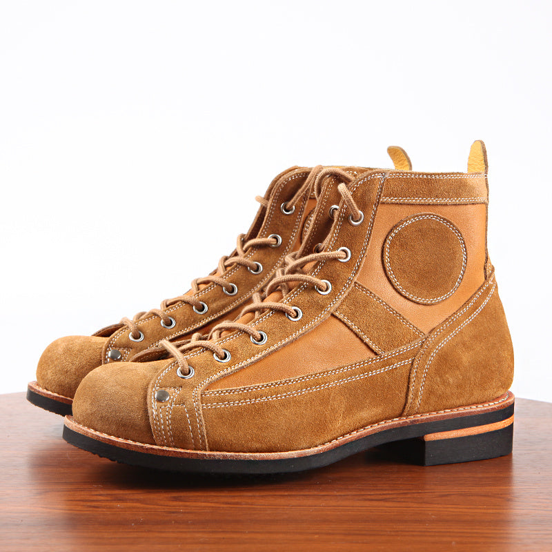 Pair of brown leather boots on a wooden surface with a white background