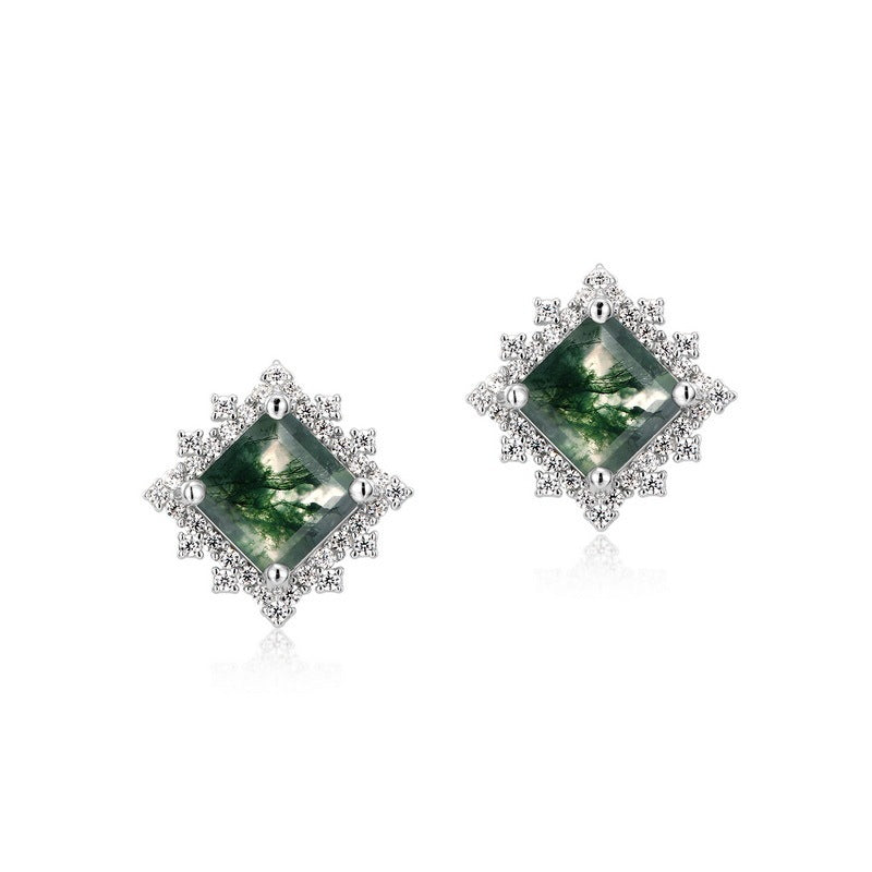Pair of diamond-shaped green gemstone earrings with silver accents on a white background