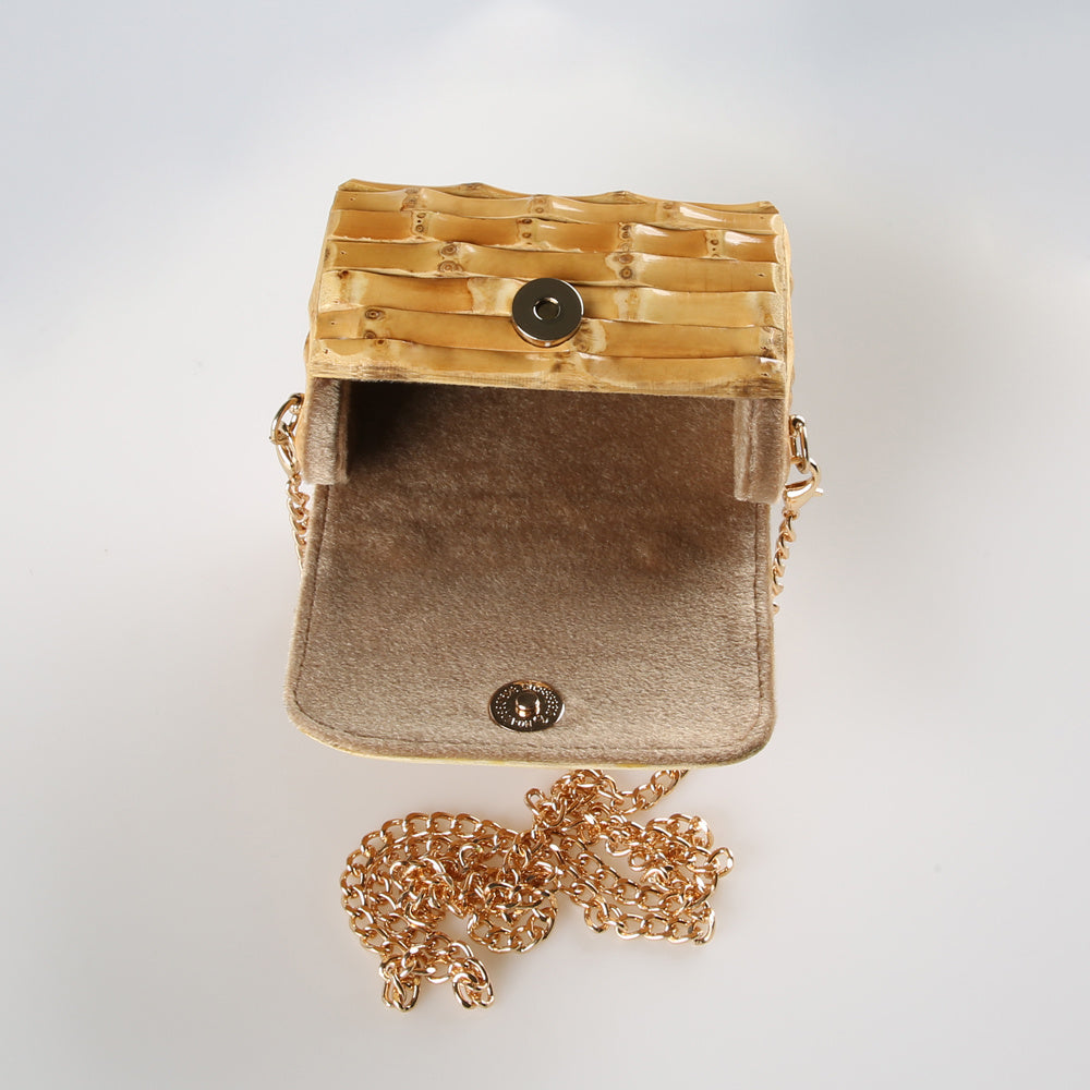 Gold handbag with a chain on a light gray background
