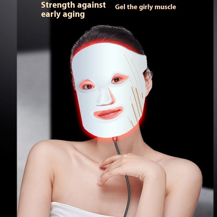 Person wearing a LED face mask with text about anti-aging and muscle toning.