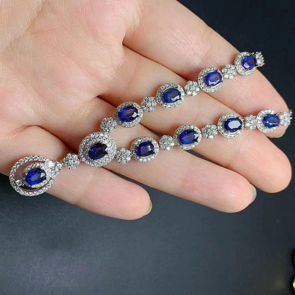 Bracelet with blue gemstones held in a hand against a dark background